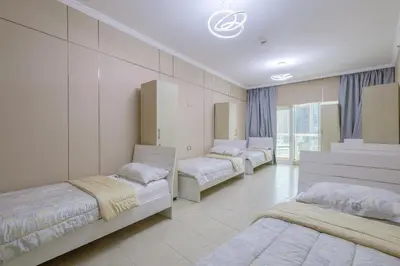 three beds in a room with white walls at Prime Downtown Male Dormitory Comfort Meets Convenience in Dubai