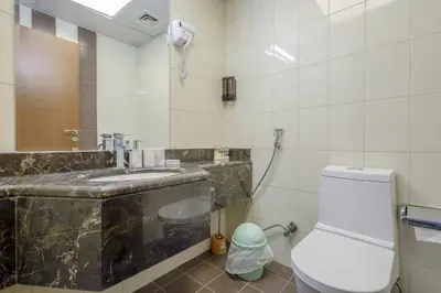 a bathroom with a sink and a toilet and a mirror at Prime Downtown Male Dormitory Comfort Meets Convenience in Dubai