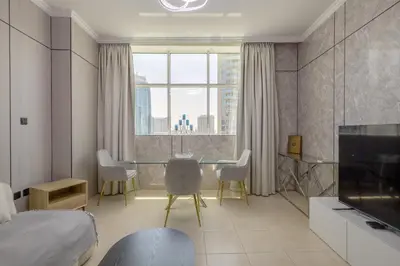 a room with a table and chairs and a television at Prime Downtown Male Dormitory Comfort Meets Convenience in Dubai