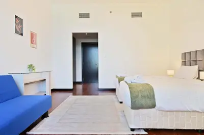 a bedroom with a bed and a blue couch at Luxury 2BR with Contemporary Design & Great Views in Dubai
