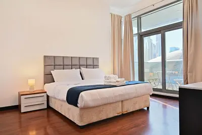 a bedroom with a bed and a large window at Luxury 2BR with Contemporary Design & Great Views in Dubai