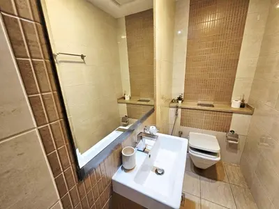 a bathroom with a sink and a toilet and a mirror at SUNRISE HOMES - Charming 1-BR Just a walk to JBR Beach in Dubai