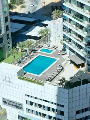 an overhead view of a building with a swimming pool at SUNRISE HOMES - Charming 1-BR Just a walk to JBR Beach in Dubai