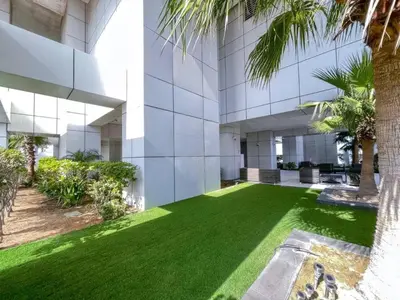 an exterior view of a building with green grass at SUNRISE HOMES - Charming 1-BR Just a walk to JBR Beach in Dubai