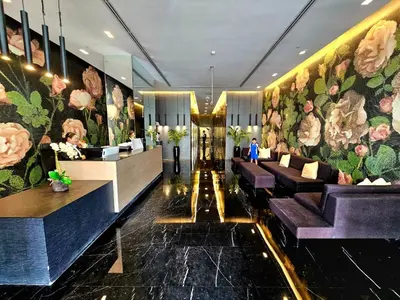 a lobby with purple couches and flowers on the wall at SUNRISE HOMES - Charming 1-BR Just a walk to JBR Beach in Dubai