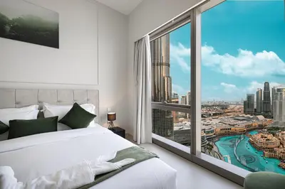 a bedroom with a white bed and a large window at Luxury 2BR Burj Fountain View Walk to Dubai Mall in Dubai