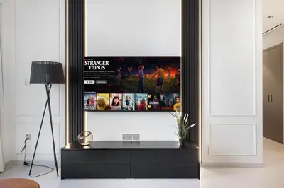 a living room with a tv on a wall at 2BR Walk to Burj Mall & Opera Pool View in Dubai