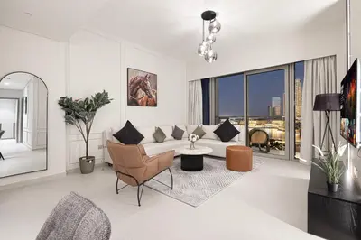 a living room with a couch and a table at 2BR Walk to Burj Mall & Opera Pool View in Dubai