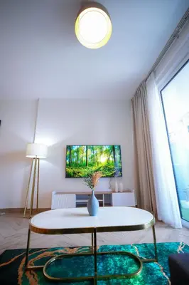 a living room with a table and a tv on the wall at Modern 1BR 4 Guests Dubai World Trade Center in Dubai