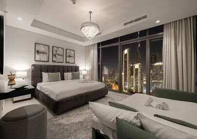a bedroom with two beds and a large window at Paramount Midtown Hotel - Luxury Apartments & Infinity Pool with Burj Khalifa View in Dubai