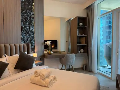 a hotel room with a bed with a towel on it at Stylish 2BR - Burj Khalifa - Waterfront View - Fully Furnished in Dubai