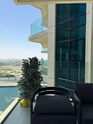a balcony with a chair and a large window at Stylish 2BR - Burj Khalifa - Waterfront View - Fully Furnished in Dubai