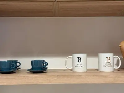 four coffee mugs are sitting on a shelf at Stylish 2BR - Burj Khalifa - Waterfront View - Fully Furnished in Dubai