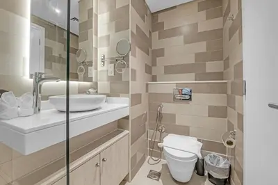 a bathroom with a toilet and a sink at Serene Palm Studio - Rooftop Infinity Pool & Private Beach Access in Dubai
