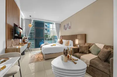a hotel room with a bed and a living room at Serene Palm Studio - Rooftop Infinity Pool & Private Beach Access in Dubai