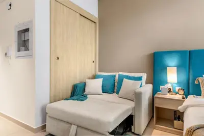 a room with a bed and a couch and a table at Stunning Palm Studio - Rooftop Infinity Pool & Private Beach Access - MaxStays in Dubai