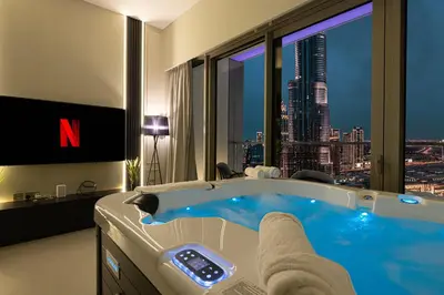 a bathroom with a tub with a view of a skyscraper at Luxury 2BR Burj View Private Hot Tub Walk to DubaiMall in Dubai
