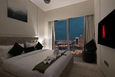 a bedroom with a bed with a view of a city at Luxury 2BR Burj View Private Hot Tub Walk to DubaiMall in Dubai