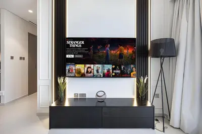 a living room with a tv hanging on a wall at Luxury 2BR Burj View Private Hot Tub Walk to DubaiMall in Dubai