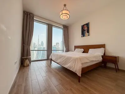 a bedroom with a bed and a large window at Premium 1BR W Canal & Burj View in Al Habtoor City in Dubai