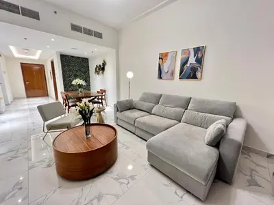 a living room with a couch and a table at Premium 1BR W Canal & Burj View in Al Habtoor City in Dubai