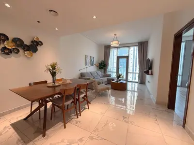 a living room with a table and a couch at Premium 1BR W Canal & Burj View in Al Habtoor City in Dubai