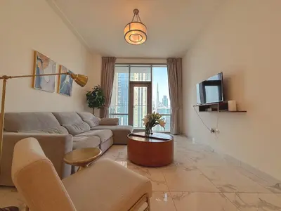 a living room with a couch and a tv at Premium 1BR W Canal & Burj View in Al Habtoor City in Dubai
