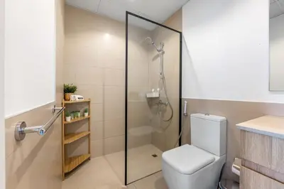 a bathroom with a shower with a toilet and a sink at Waves - Stylish Blue Haven near Town Square Park in Dubai