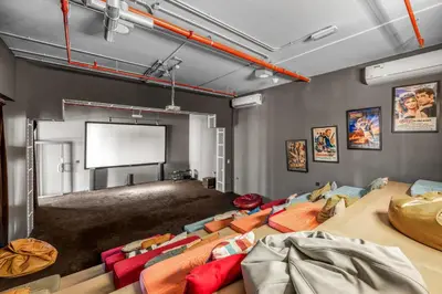 a room with a projection screen and a couch at Waves - Stylish Blue Haven near Town Square Park in Dubai