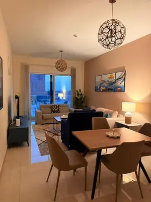 a living room with a couch and a table and chairs at Stunning Park View 1Bhk 4pax in Dubai