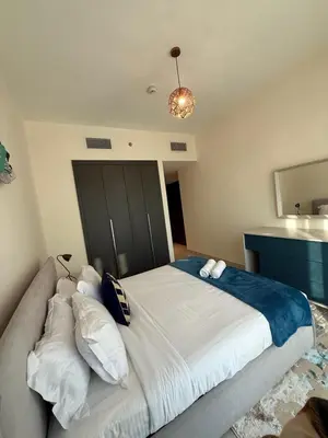 a bedroom with a large bed and a couch at Stunning Park View 1Bhk 4pax in Dubai