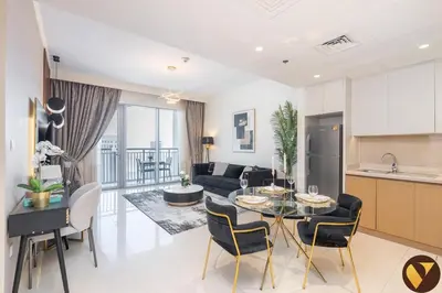 a kitchen and a living room with a table and chairs at Vogue Creek Harbour, Harbour Views Tower Waterfront Living Close to Downtown, Burj Khalifa and Dubai Mall, One Bedroom Apartment with Balcony and Canal View, Access to all Amenities in Dubai