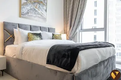 a bedroom with a large bed with a large window at Vogue Creek Harbour, Harbour Views Tower Waterfront Living Close to Downtown, Burj Khalifa and Dubai Mall, One Bedroom Apartment with Balcony and Canal View, Access to all Amenities in Dubai