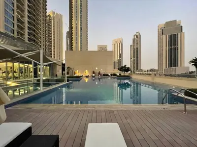 a swimming pool in a city with tall buildings at Vogue Creek Harbour, Harbour Views Tower Waterfront Living Close to Downtown, Burj Khalifa and Dubai Mall, One Bedroom Apartment with Balcony and Canal View, Access to all Amenities in Dubai