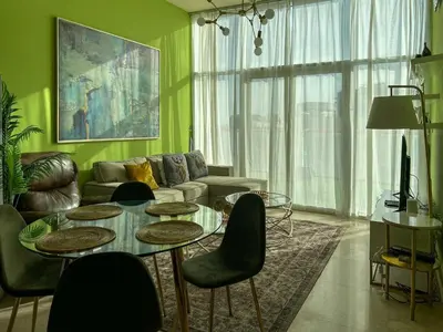 a living room with a table and a couch at Bespoke Holiday Homes - Upscale 1BR Penthouse in Millenium Binghatti in Dubai