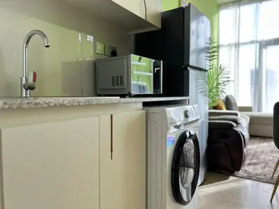a kitchen with a washing machine and a sink at Bespoke Holiday Homes - Upscale 1BR Penthouse in Millenium Binghatti in Dubai