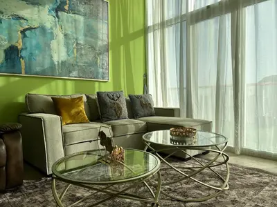 a living room with a couch and two glass tables at Bespoke Holiday Homes - Upscale 1BR Penthouse in Millenium Binghatti in Dubai