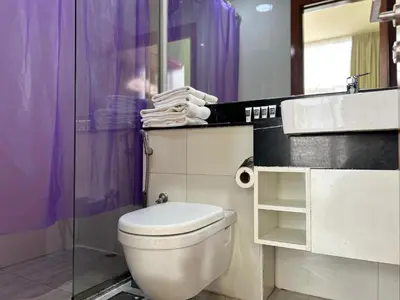 a bathroom with a toilet and a glass shower at Bespoke Holiday Homes - Upscale 1BR Penthouse in Millenium Binghatti in Dubai