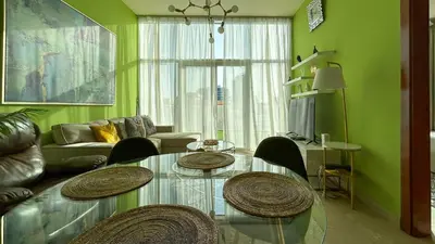 a living room with a glass table and chairs at Bespoke Holiday Homes - Upscale 1BR Penthouse in Millenium Binghatti in Dubai