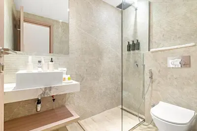a bathroom with a shower and a sink and a toilet at Bright 2BR Retreat Balcony & Pool Near Jumeirah Village Circle in Dubai