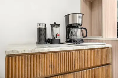a kitchen counter with two appliances on top of it at Bright 2BR Retreat Balcony & Pool Near Jumeirah Village Circle in Dubai