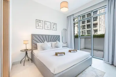 a white bedroom with a bed and a window at Modern Family Home with Dubai Skyline Views in Dubai