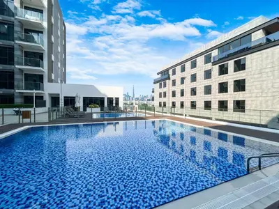 a large swimming pool in the middle of two buildings at Modern Family Home with Dubai Skyline Views in Dubai