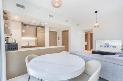a white dining room with a white table and chairs at Modern Family Home with Dubai Skyline Views in Dubai