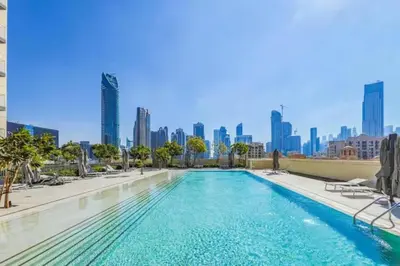 a swimming pool with a city skyline in the background at Burj Khalifa View - Immersive Expérience - Downtown - DUBAI 3BR in Dubai