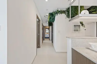 a hallway leading into a kitchen with white walls at Burj Khalifa View - Immersive Expérience - Downtown - DUBAI 3BR in Dubai