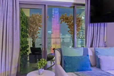 a living room with a couch and a large window at Burj Khalifa View - Immersive Expérience - Downtown - DUBAI 3BR in Dubai