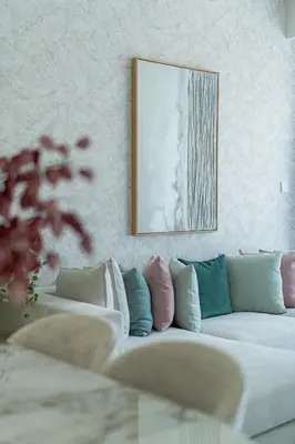 a living room with a white couch with colorful pillows at Nasma Luxury Stays - Sky-High Serenity in Stylish 2BR Retreat in Dubai