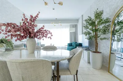 a dining room with a white table and chairs at Nasma Luxury Stays - Sky-High Serenity in Stylish 2BR Retreat in Dubai