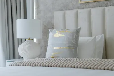 a bed with a lamp and a pillow on it at Nasma Luxury Stays - Sky-High Serenity in Stylish 2BR Retreat in Dubai